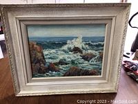 Framed oil painting of sea landscape with waves crashing against rocks, signed by Roy Greenaway