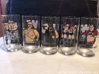 Front view of five WWF glasses displaying colorful character illustrations and WWF logos.