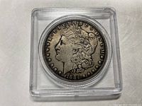 Obverse side of 1884 Morgan silver dollar coin showing Lady Liberty profile with date 1884
