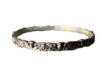 Photo showing the full circular bracelet with cherub face and ornamental scrollwork in relief.