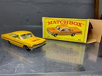 Front and left side view of yellow taxi cab with original box behind it, showcasing the car and box design.