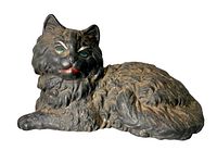 Side angle of the cast iron reclining cat doorstop showing the front details with painted eyes and mouth.