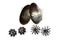 Photo showing all three pairs of sterling silver earrings on post backings: large hammered oval pair, small circular cluster pair, small starburst pair.