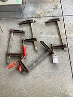 Overview of the 4 metal bar clamps, showing their size, condition and handle types.