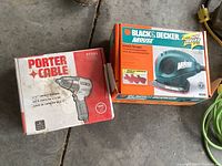 Photo of boxed Porter Cable 1/2 inch impact wrench next to boxed Black & Decker Mouse sander/polisher