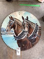 Full view of the round saw blade with two horses painted and signed by artist.
