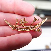 Front view of the 14K gold floral brooch showing seed pearls, one missing pearl visible on a bud