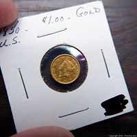 Obverse view of 1851 gold dollar in paper coin holder