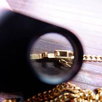 Macro view of clasp under loupe showing “18k” hallmark