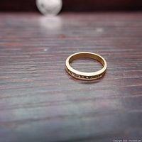 Ring resting on wooden surface showing profile and channel setting of diamonds