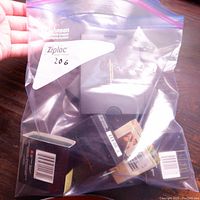 Five black presentation boxes of mint coins in a Ziploc bag