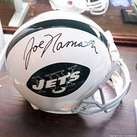 Front right side view of white Jets helmet showing green logo and Joe Namath signature