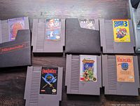Eight NES game cartridges laid out on a surface showing front labels for games Final Fantasy, Castlevania, Faxanadu, Castlevania II, Super Mario Bros 3, and others.
