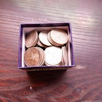 Small purple box containing stacked silver quarters viewed from above