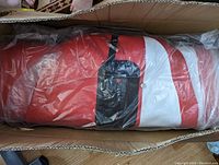 Paddle board in original box inside clear plastic bag showing sealed, unused condition