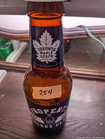 Front view of amber glass coin bank with Toronto Maple Leafs logo and label, numbered 254