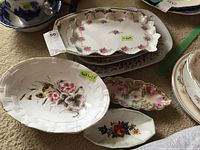 Various china serving ware pieces grouped together showing different floral patterns and sizes