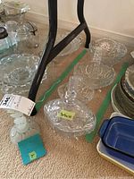 Image showing glassware items at base of metal furniture, including covered dish, baskets, and a glass bottle
