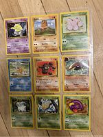Photo showing the front side of 9 original 90s Pokémon Base Set cards in sleeves, each featuring different Pokémon with classic artwork and yellow borders.