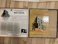 Photo of open box set showing the vinyl record cover with detailed liner notes on the left and the hard copy book on the right.