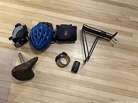 Overview of the full bike gear lot including helmet, vintage seat, light, carrying case, back rack and coiled lock