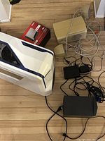 Full view of iBUYPOWER computer tower with accessories including subwoofer, speakers, router, mouse, and cables seen on floor