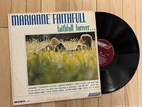 Front cover of Marianne Faithfull's 'Faithfull Forever' vinyl album showing artist lying in grass with track listings on cover.