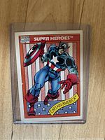 Front photo of Captain America #1 card showing comic artwork of Captain America in blue costume with shield against American flag background.