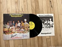 Photo showing the front cover of the vinyl LP 'Smorgasbord' by Sharon, Lois & Bram with signatures and the vinyl pressed record partially visible.