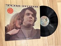 Front cover of 'The Circle Game' vinyl LP by Tom Rush laid flat on floor with the vinyl record partially out of the sleeve showing the record surface and label.