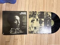 Front cover of the vinyl record showing Woody Guthrie's portrait and a performance image.