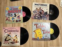 Four vinyl record albums showing titles and cover art: Renco presents Walt Disney with Mickey Mouse, The Best of Walt Disney with multiple characters, Cinderella, and Tubby the Tuba.