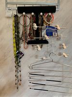 Full view of jewelry holders, necklaces, and skirt/pant hangers on wall