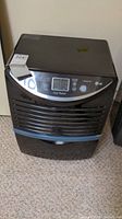 Front view of LG black dehumidifier with control panel showing buttons, digital display, and LG logo.