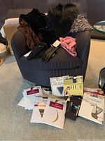 Photo showing assortment of gloves, scarves, vintage fur stole, and multiple pantyhose packs on a chair and floor