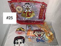 Group of items including large plastic bag, beaded Betty Boop coin purse, beaded Asian boy coin purse and additional small items on white background