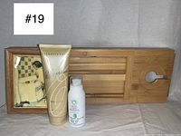 Bamboo bathtub tray with framed tile, Herbal Essences dry shampoo, and Elizabeth Grant Body Lotion arranged for display