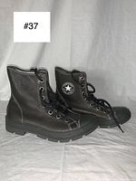 Side profile of black leather Converse combat-style high top shoes, size 8.