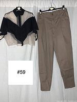 Wide view showing both sheer black panel cropped top and tan high waisted pants hanging on a white backdrop.