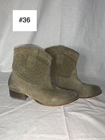 Side view of green suede ankle boots showing basket weave design and wooden heel
