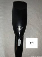 Front view of Dr. Scholl's handheld massager showing black body with white power switch and Dr. Scholl's logo.