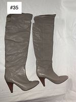 Photo showing both knee-high boots side by side, showcasing leather material and height up to the knee.
