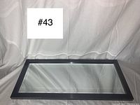 Full front view of the grey framed beveled mirror lying flat, showing size and shape.