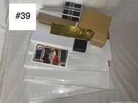 Four bundles of five assorted gift boxes in various colors and designs, stacked with a Santa Claus postcard on top