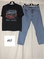 Full view of black short sleeve t-shirt with racing graphic and vintage Dakota blue jeans laid side by side