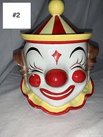 Front view of circus clown head cookie jar with striped hat lid in place