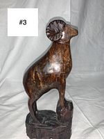 Front view of vintage hand carved wooden ram sculpture showing detailed carving on face, body and base.