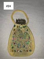Front view of yellow beaded vintage purse with floral and polka dot bead pattern and accordion metal frame