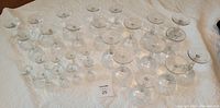 Full set of 27 crystal stemware glasses arranged by size on a white background showing three groups of nine glasses each.