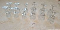 12 crystal wine glasses arranged on a cloth surface, 6 smaller and 6 larger glasses, showing overall set condition and size difference